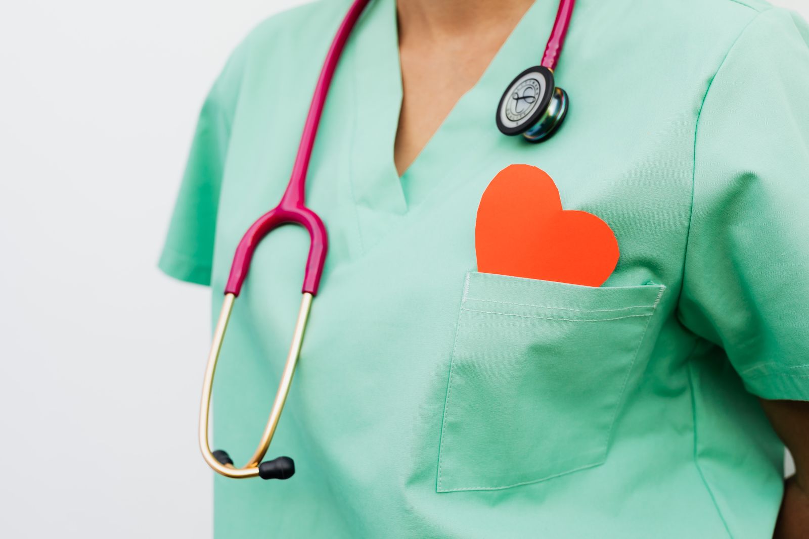 Healthcare worker wearing scrubs with a heart symbol of compassion